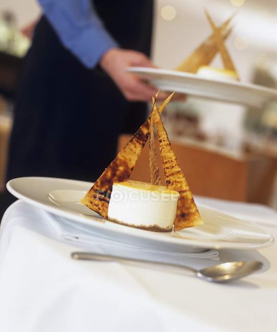 Vista ravvicinata di dessert alla panna con wafer con persona sullo sfondo — Foto stock