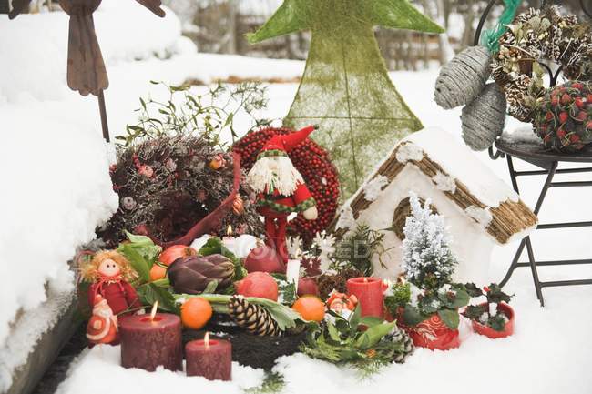 Decoraciones navideñas en jardín nevado - foto de stock