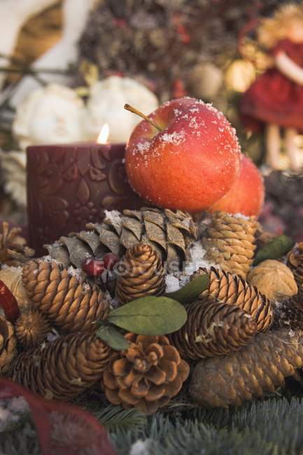 Zapfen mit roten Äpfeln und Kerze — Stockfoto