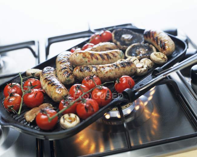 Sausages with mushrooms and tomatoes — Stock Photo