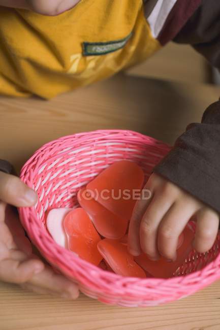 Child taking sugar heart from basket — Stock Photo