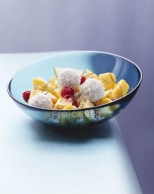 Closeup view of mango salad with raspberries and coconut balls — Stock Photo