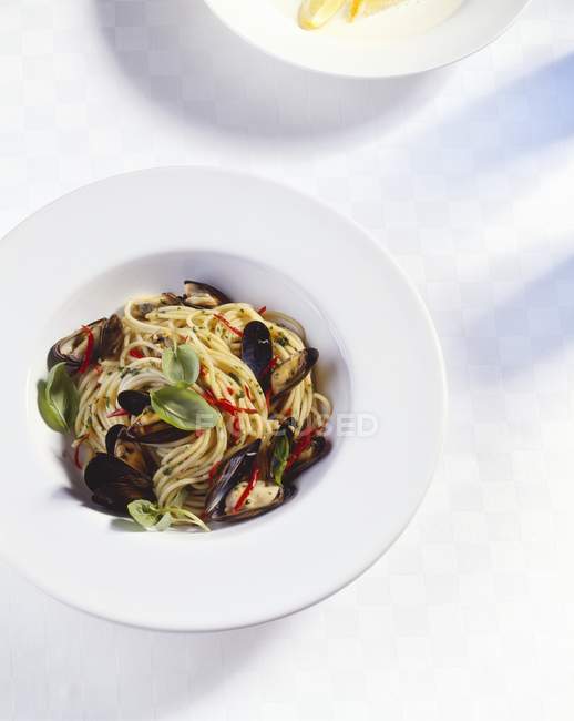 Спагетти с мидиями и базиликом — стоковое фото