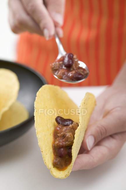 Remplir les tacos avec une cuillère — Photo de stock