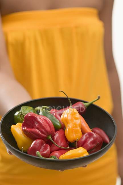 Woman holding chillies — Stock Photo