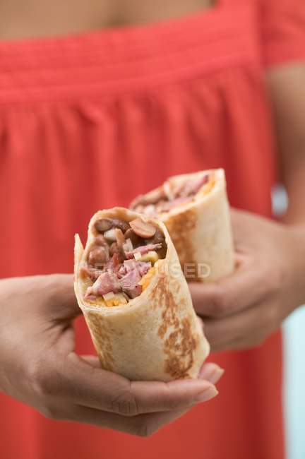 Cropped view of female hands holding two wraps — Stock Photo