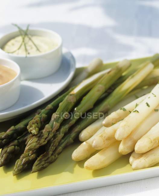 Green and white asparagus with sauces — Stock Photo