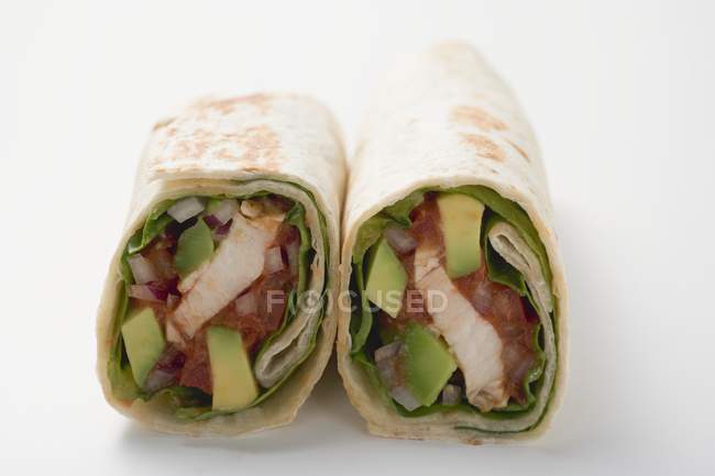 Zwei Wraps gefüllt mit Huhn und Avocado auf weißer Oberfläche — Stockfoto
