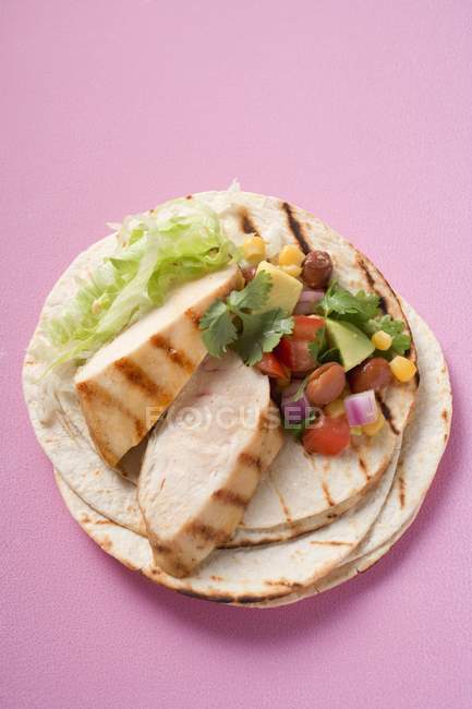 Chicken fajita with chicken breast and salsa over pink surface — Stock Photo