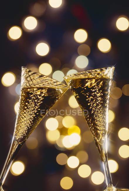 Glasses of sparkling wine being clinked — Stock Photo