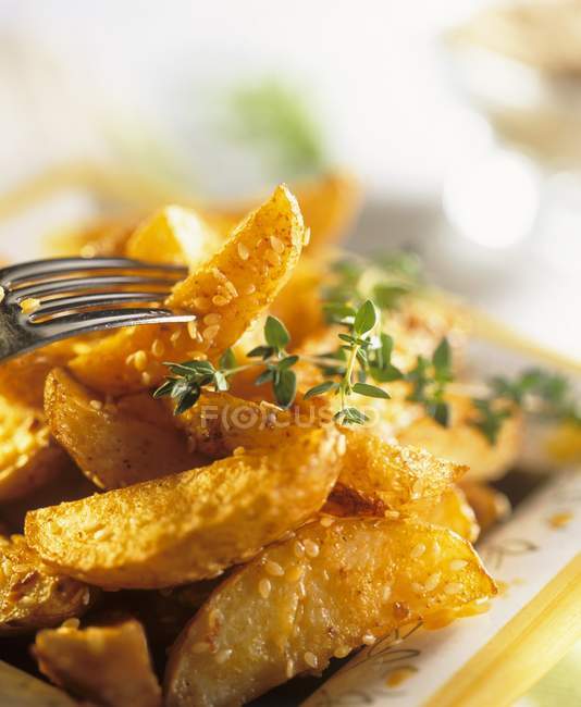 Potato wedges with sesame seeds and thyme — Stock Photo