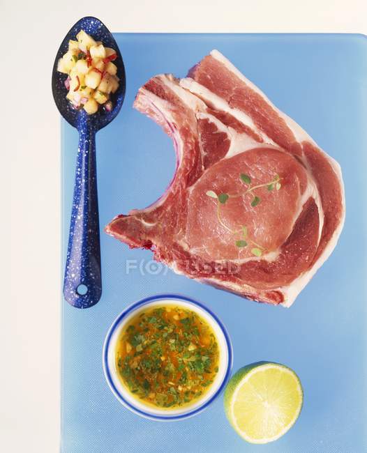 Сырая свиная отбивная с сальсой — стоковое фото