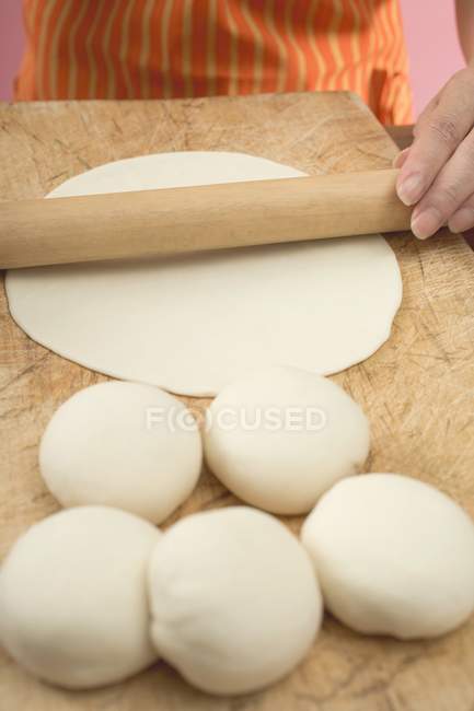Closeup view of woman rolling out tortilla dough — Stock Photo