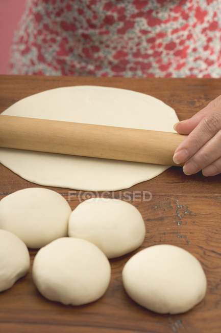 Closeup view of woman rolling out tortilla dough — Stock Photo