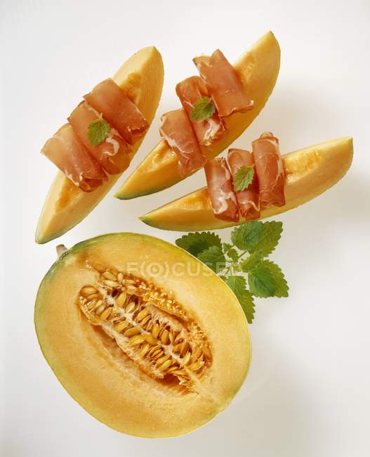 Slices of melon with ham and mint — Stock Photo