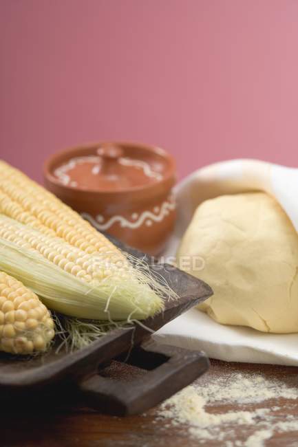 Closeup view of Tortilla dough and cobs of corn — Stock Photo