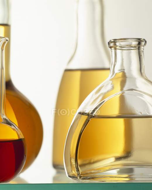 Vue rapprochée des huiles dans diverses bouteilles en verre — Photo de stock