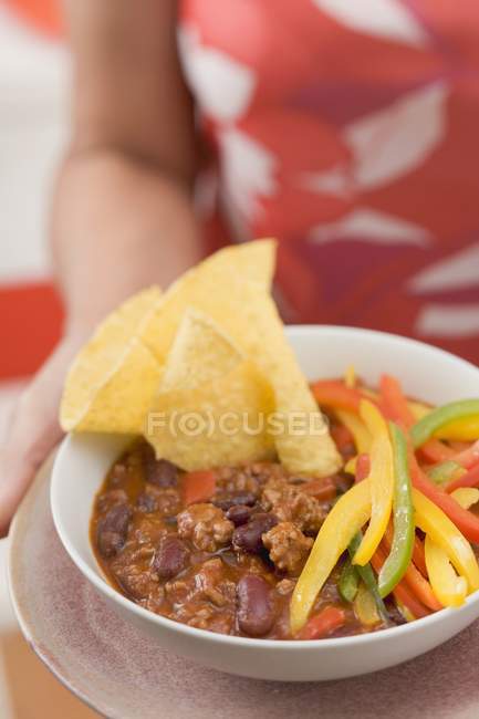 Woman serving chili con carne — Stock Photo