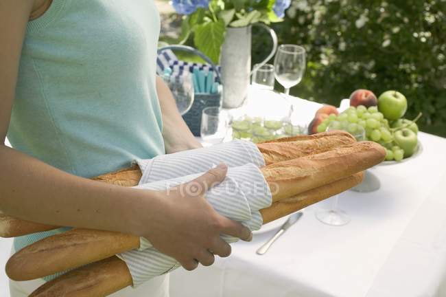 Donna che trasporta baguette — Foto stock