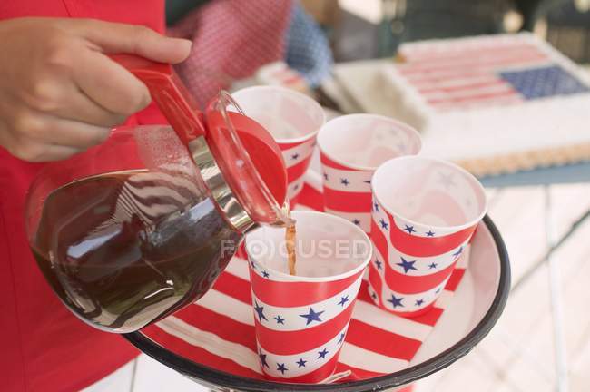 Closeup view of woman pouring coffee to paper cup — Stock Photo