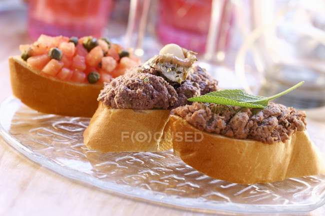 Closeup view of three canapes with different toppings — Stock Photo
