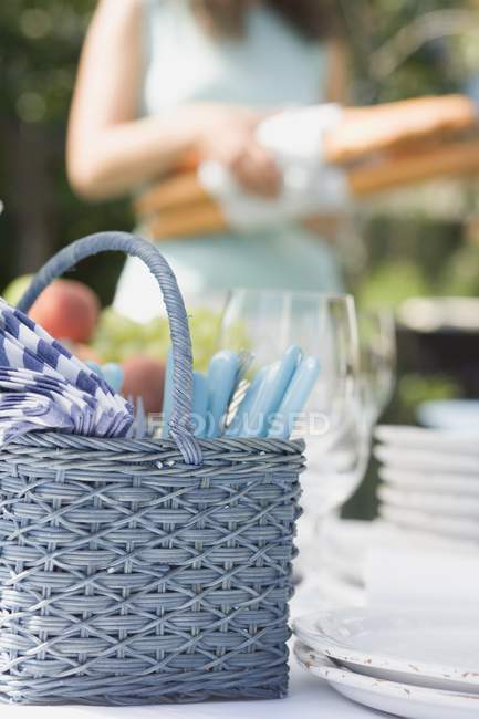 Tagsüber Blick auf den gedeckten Tisch für ein Sommerfest mit Frau im Hintergrund — Stockfoto