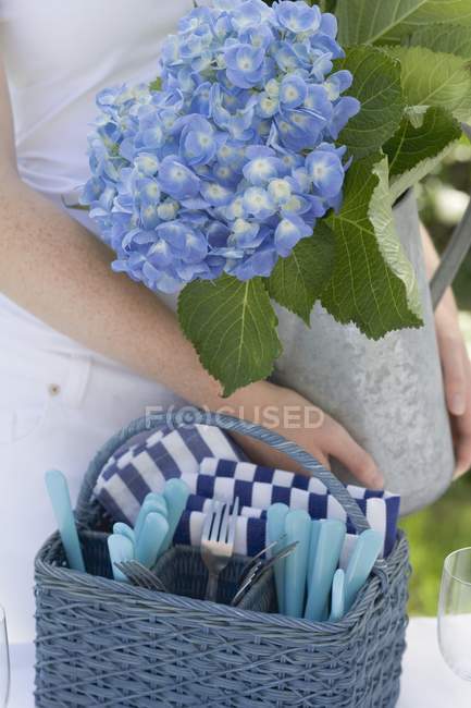 Woman decorating table with vase of flowers — Stock Photo