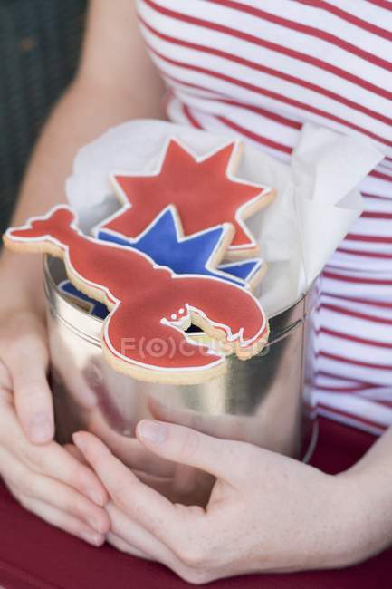 Cropped view of woman holding tin with cookies — Stock Photo