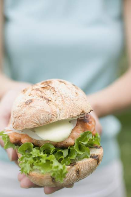 Mulher segurando frango hambúrguer — Fotografia de Stock