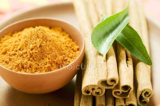 Cinnamon sticks and curry powder — Stock Photo