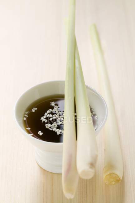 Closeup view of lemongrass on small bowl of soy sauce — Stock Photo