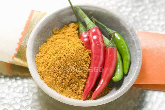 Curry powder and chili peppers — Stock Photo