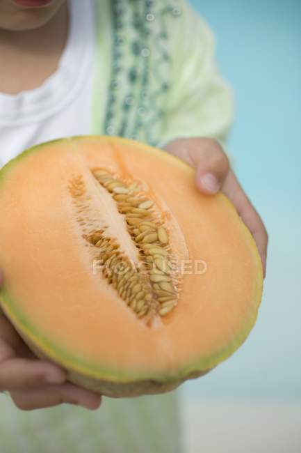 Child holding cantaloupe melon — Stock Photo