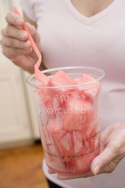 Woman eating diced melon — Stock Photo