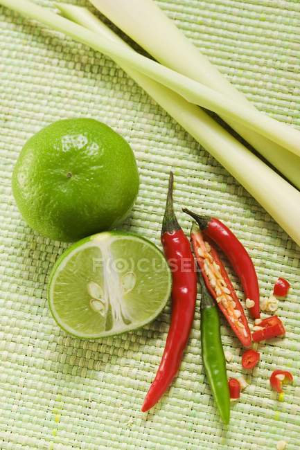 Limas, chiles y hierba de limón - foto de stock