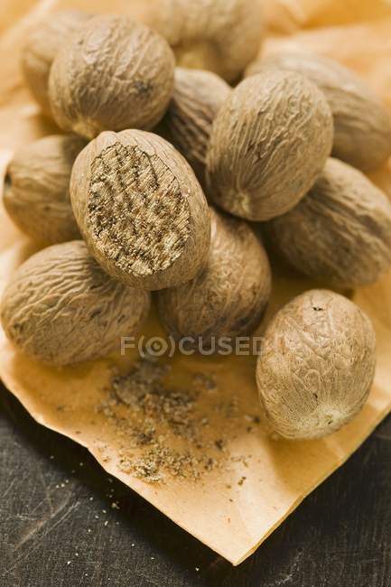 Whole Nutmegs on parchment — Stock Photo
