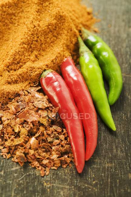 Chili peppers, chili flakes and powder — Stock Photo