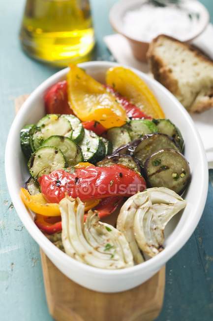 Gegrilltes Gemüse auf weißem Teller über kleinem Holztisch — Stockfoto