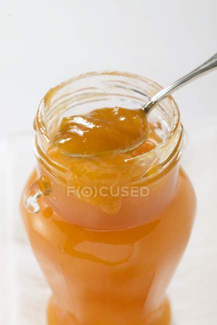 Engarrafamento de damasco em jarro com colher — Fotografia de Stock