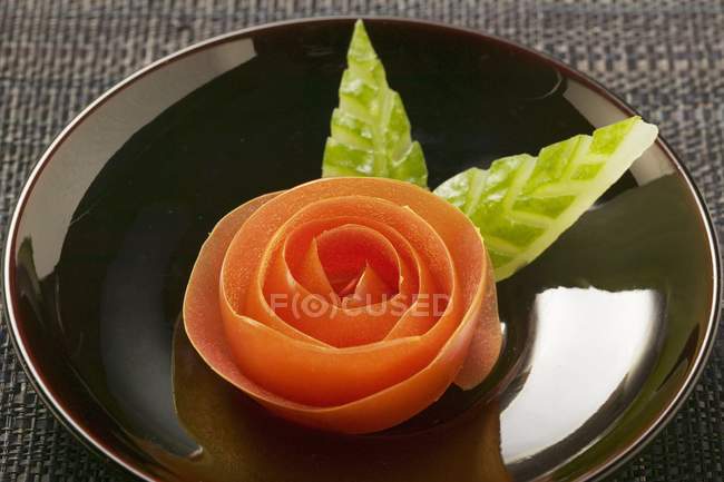 Вид крупным планом на томатную розу и резные листья огурца — стоковое фото