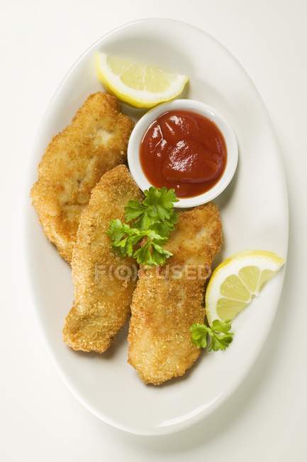 Nuggets de peixe com ketchup e limão — Fotografia de Stock