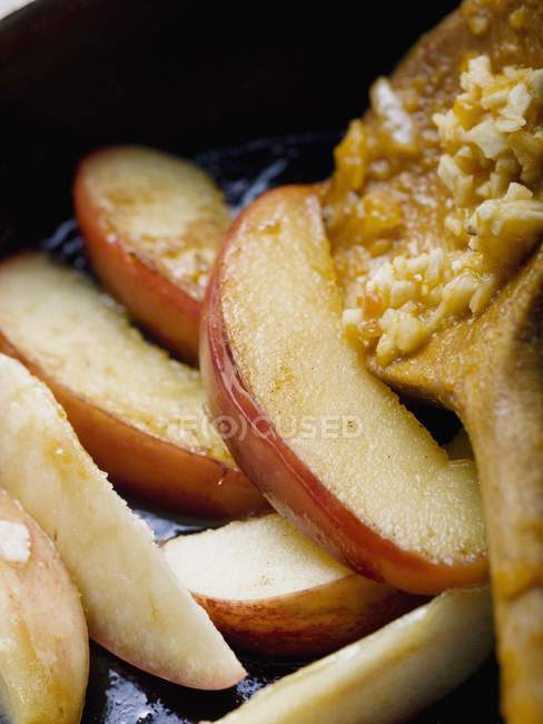 Fried apple wedges in frying pan — Stock Photo