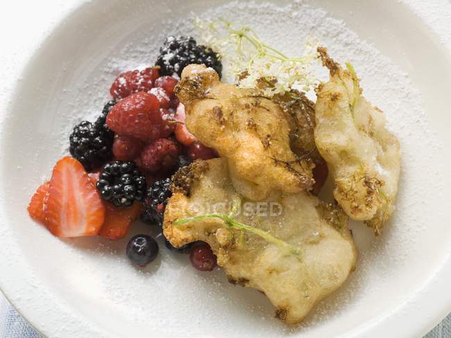 Primo piano vista di frittelle di fiori di sambuco con bacche e zucchero a velo — Foto stock