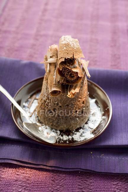 Vista de primer plano del soufflé de chocolate con rollos de chocolate y azúcar glaseado - foto de stock