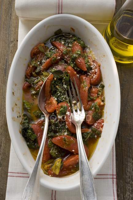 Pomodori e verza in piatto bianco con cucchiaio e forchetta — Foto stock