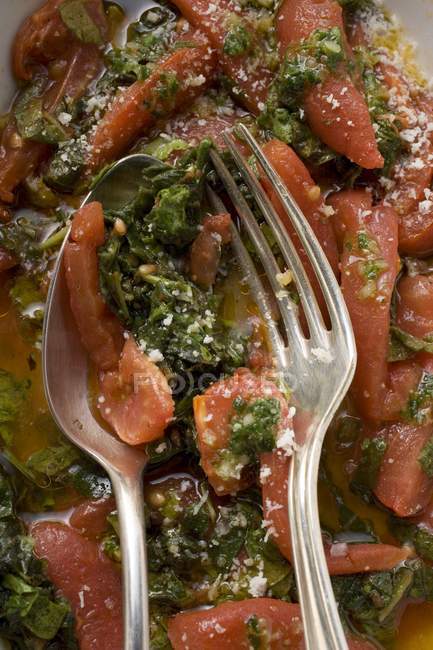 Tomates y col rizada con cuchara y tenedor - foto de stock