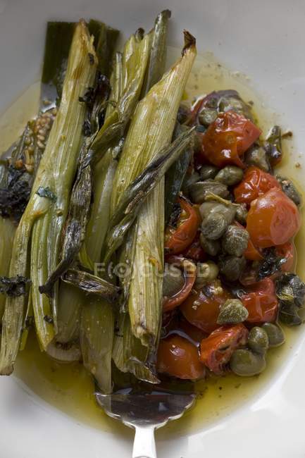 Leeks with tomatoes and capers — Stock Photo