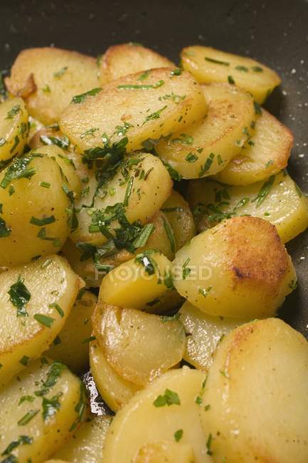 Close-up of sliced Fried potatoes with herbs — Stock Photo