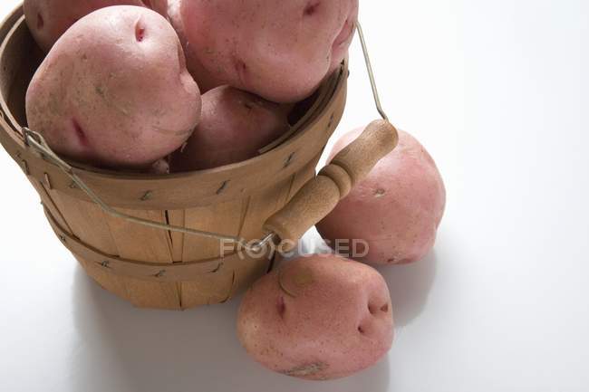 Batatas vermelhas na cesta de aparas de madeira — Fotografia de Stock