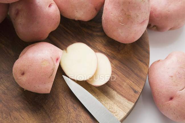 Patatas rojas enteras y cortadas en rodajas - foto de stock